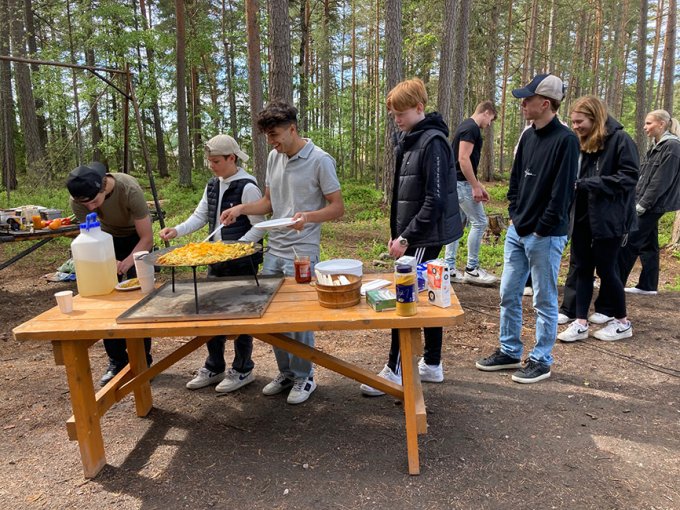 Elever som äter mat ute i skogen